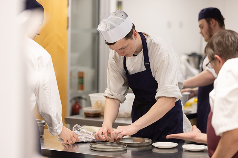 Gateshead College Catering Student preparing a dish in the training kitchen of Enfields Kitchen